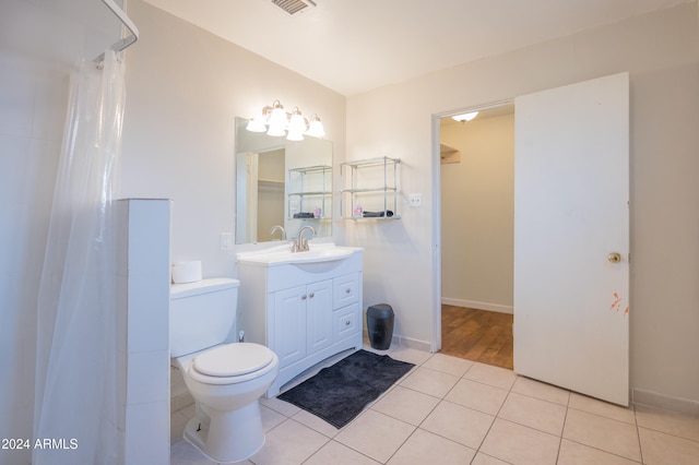 bathroom with toilet, tile patterned floors, and vanity