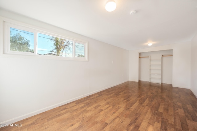 unfurnished bedroom featuring a closet and dark hardwood / wood-style flooring