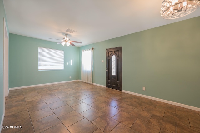 foyer entrance with ceiling fan and tile patterned flooring