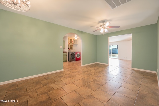 tiled spare room featuring ceiling fan with notable chandelier and washing machine and dryer