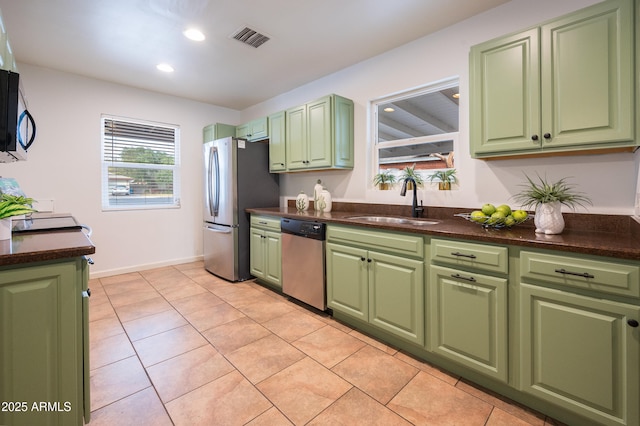 kitchen with light tile patterned flooring, green cabinets, stainless steel appliances, and sink