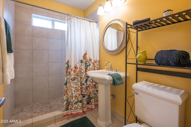 bathroom featuring toilet, sink, tile patterned floors, and a shower with shower curtain