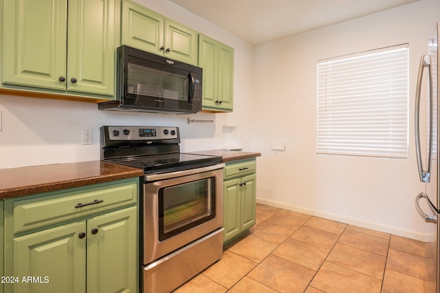 kitchen with green cabinets, stainless steel appliances, and light tile patterned flooring