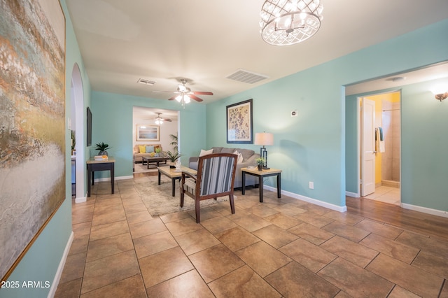 living room featuring ceiling fan with notable chandelier