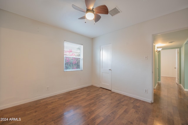 spare room with ceiling fan and dark wood-type flooring