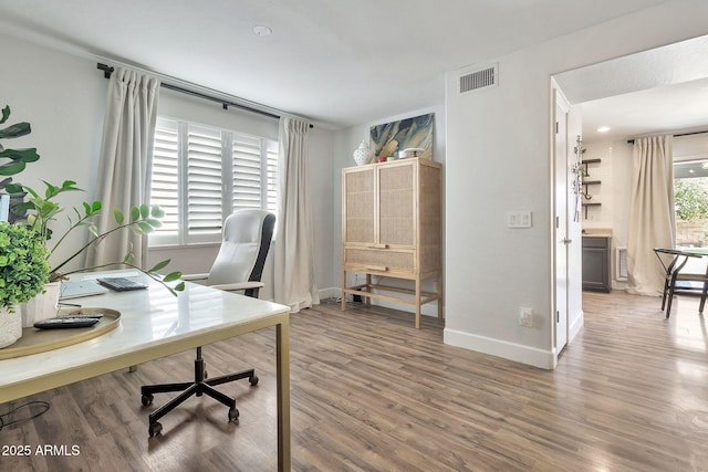 home office with visible vents, baseboards, and wood finished floors