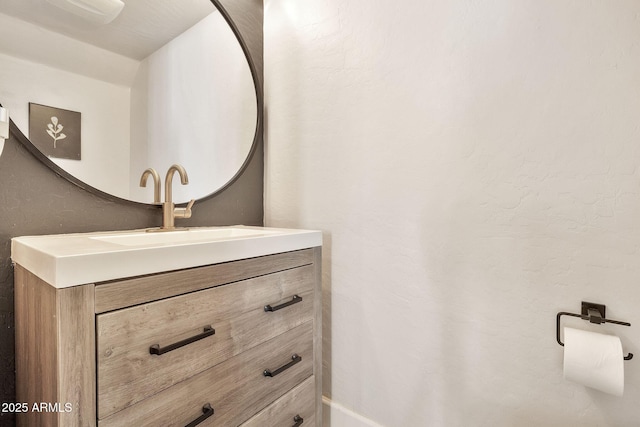 bathroom with vanity and a textured wall