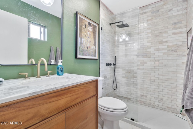 bathroom with a shower stall, toilet, and vanity