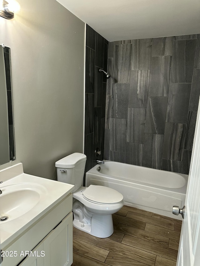 full bath featuring vanity, bathing tub / shower combination, toilet, and wood finished floors