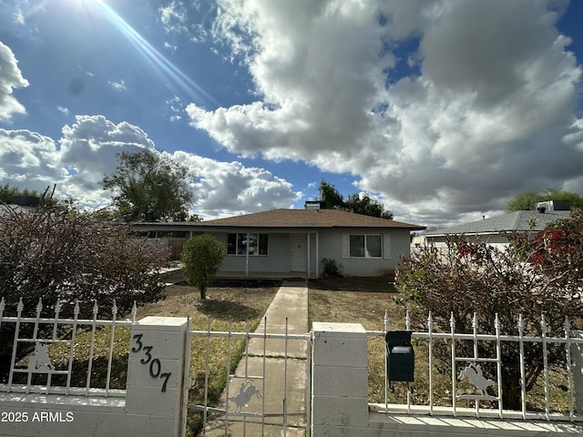 view of front of house with a fenced front yard and a gate