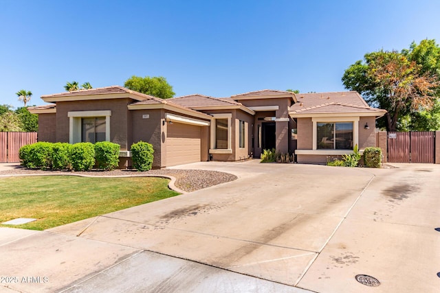 557 S Lemon Ct, Gilbert, AZ 85296 - prairie-style house with stucco siding, an attached garage, concrete driveway, a gate, and a tile roof