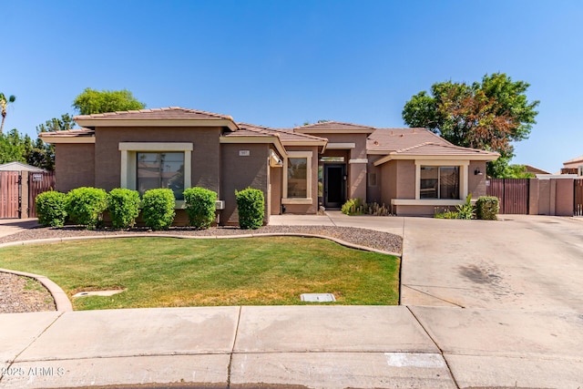 557 S Lemon Ct, Gilbert, AZ 85296 - prairie-style house featuring a gate, stucco siding, a tiled roof, and driveway