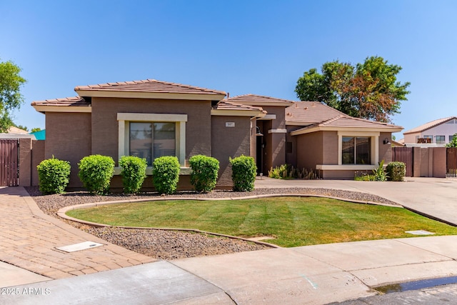 557 S Lemon Ct, Gilbert, AZ 85296 - view of front of home featuring a tile roof, stucco siding, and a gate