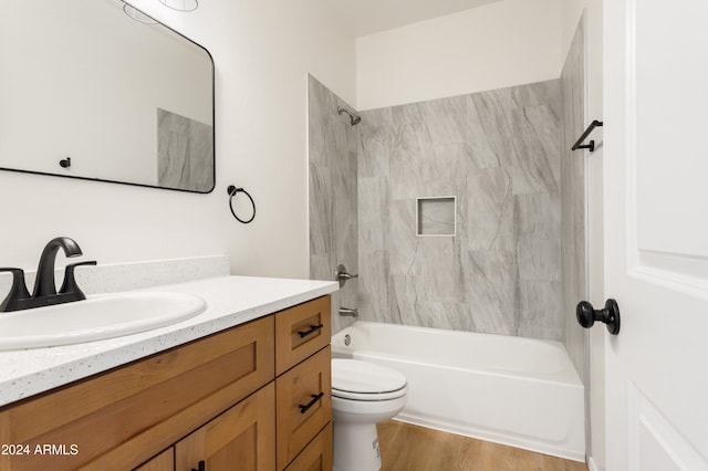 full bathroom featuring vanity, wood-type flooring, tiled shower / bath combo, and toilet