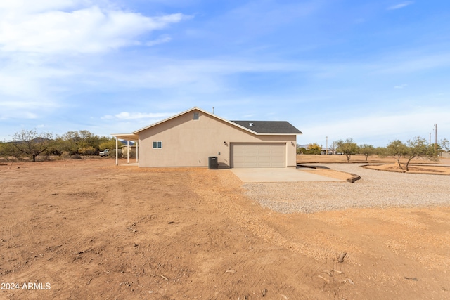 view of property exterior featuring central air condition unit and a garage