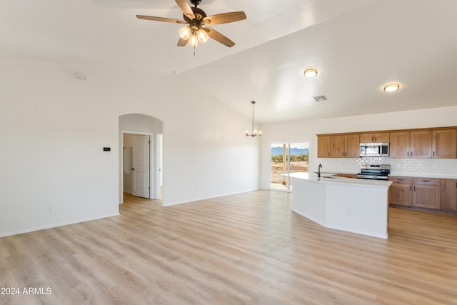 kitchen with hanging light fixtures, high vaulted ceiling, light wood-type flooring, and appliances with stainless steel finishes