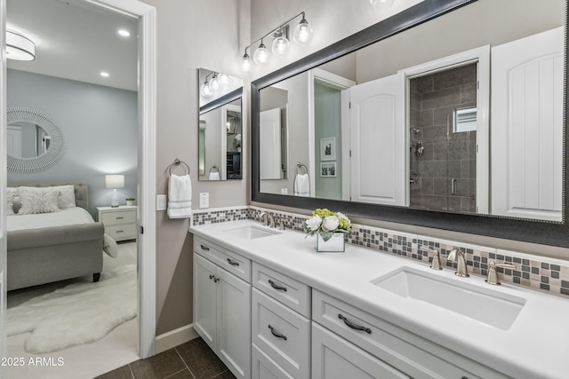 bathroom featuring tile patterned flooring, vanity, a tile shower, and tasteful backsplash