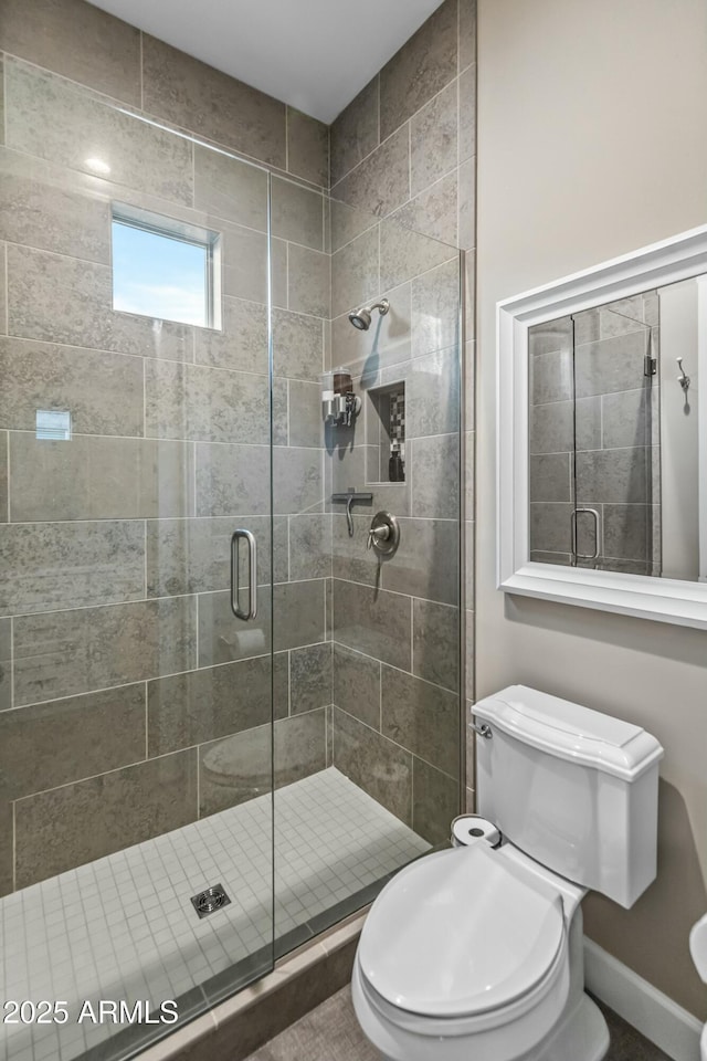 bathroom featuring toilet and an enclosed shower