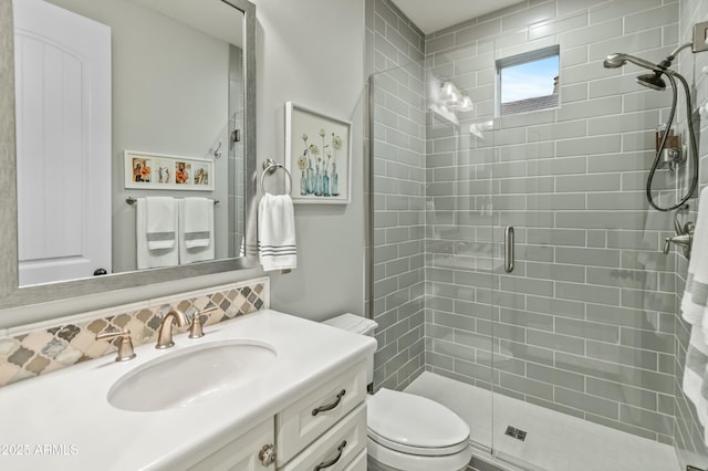 bathroom with vanity, a shower with shower door, decorative backsplash, and toilet