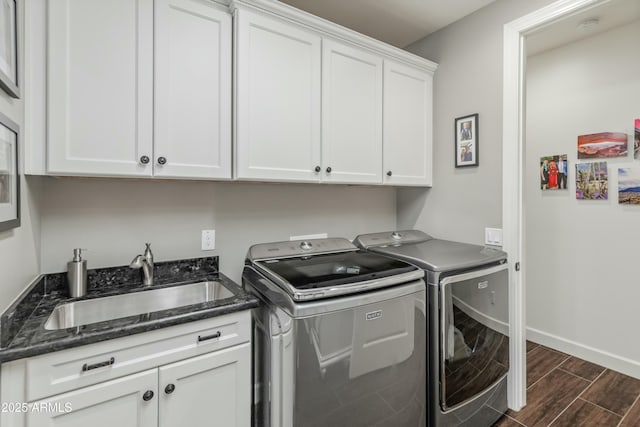 laundry room featuring cabinets, sink, and separate washer and dryer