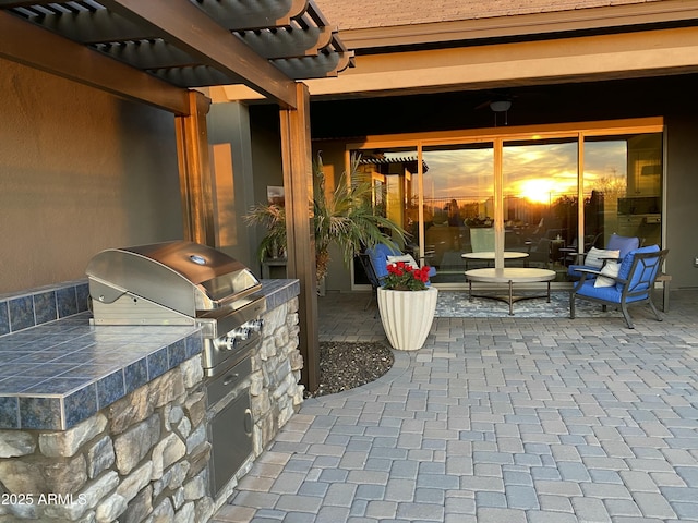 view of patio / terrace featuring area for grilling, exterior kitchen, and a pergola