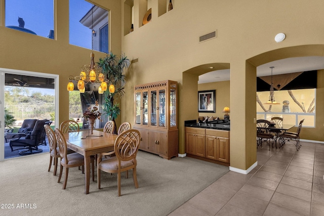 13827 N Mesquite Ln, Fountain Hills, AZ 85268 - dining space with visible vents, baseboards, arched walkways, light colored carpet, and light tile patterned flooring