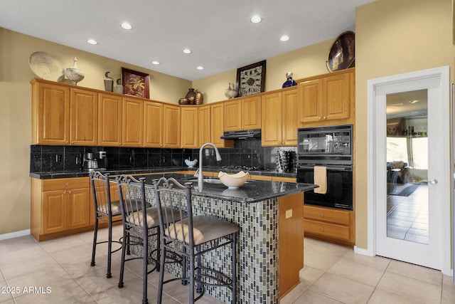 13827 N Mesquite Ln, Fountain Hills, AZ 85268 - kitchen with dark countertops, black appliances, a kitchen bar, and under cabinet range hood