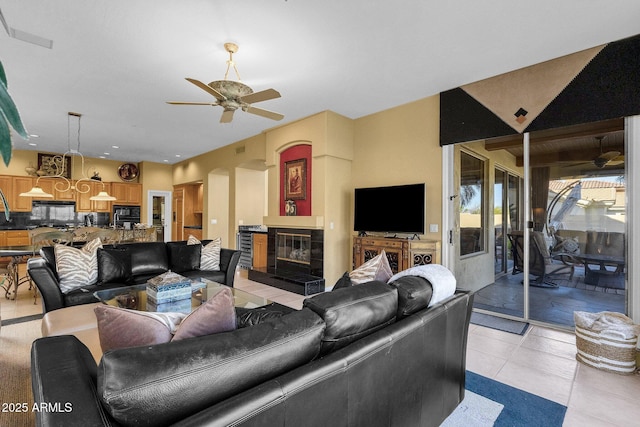 13827 N Mesquite Ln, Fountain Hills, AZ 85268 - living room featuring a tiled fireplace, light tile patterned floors, a ceiling fan, visible vents, and arched walkways