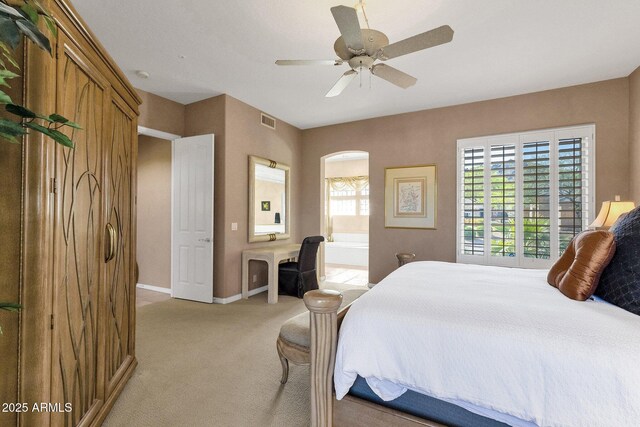13827 N Mesquite Ln, Fountain Hills, AZ 85268 - bedroom with visible vents, baseboards, ensuite bathroom, a ceiling fan, and light colored carpet