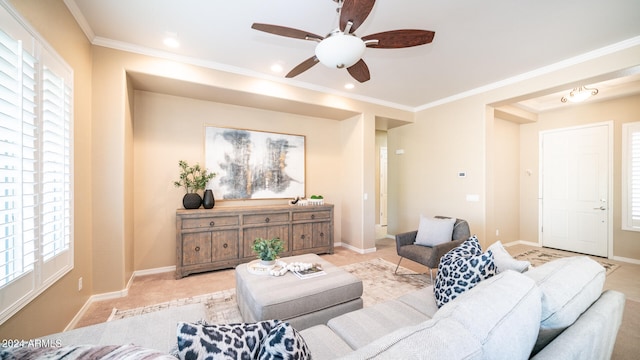 living room with light carpet, ceiling fan, plenty of natural light, and crown molding