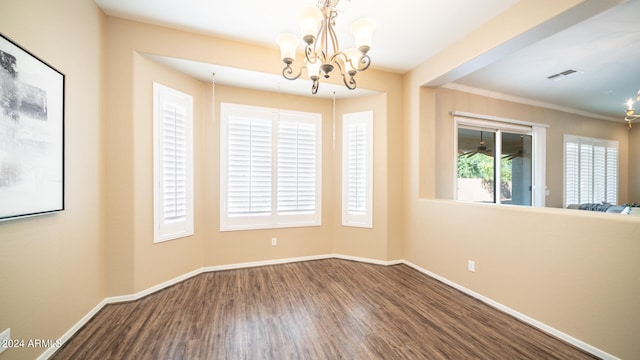 empty room featuring ornamental molding, hardwood / wood-style floors, and a chandelier