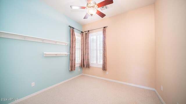 carpeted spare room with ceiling fan