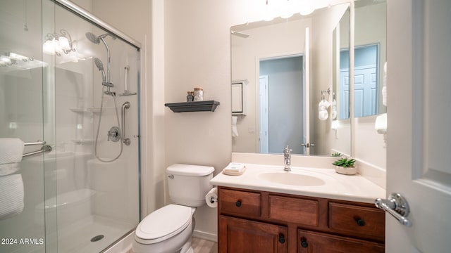 bathroom featuring vanity, toilet, and an enclosed shower