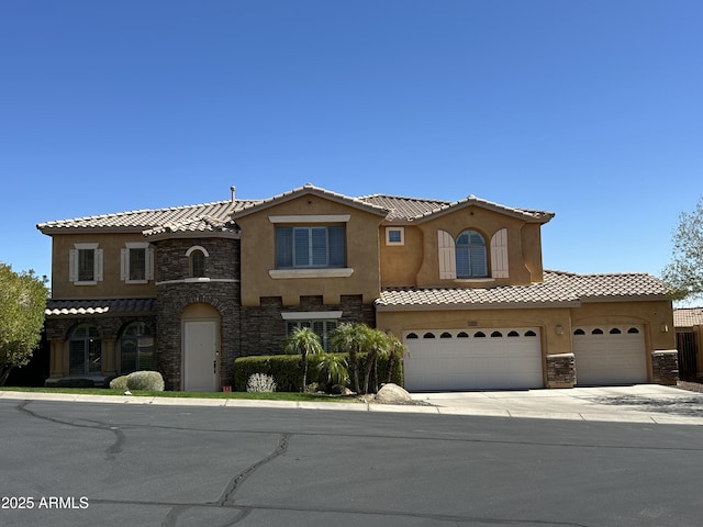 mediterranean / spanish-style home with driveway, an attached garage, stucco siding, stone siding, and a tiled roof