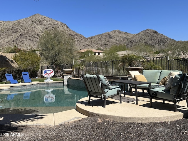 view of swimming pool featuring a patio area, a fenced in pool, a mountain view, and fence