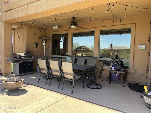 view of patio with ceiling fan, a fire pit, a grill, and outdoor dining space