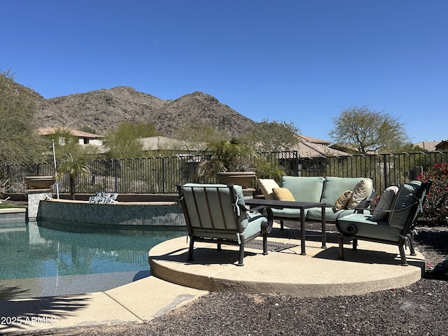 view of swimming pool featuring a fenced in pool, fence, an outdoor hangout area, a patio area, and a mountain view
