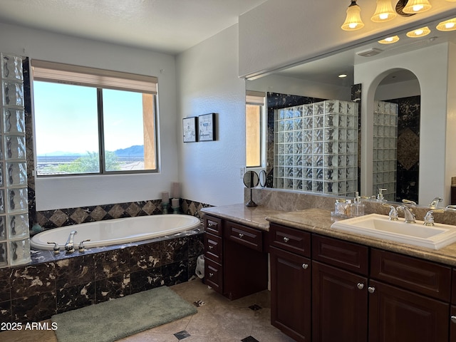 full bathroom with vanity and a garden tub