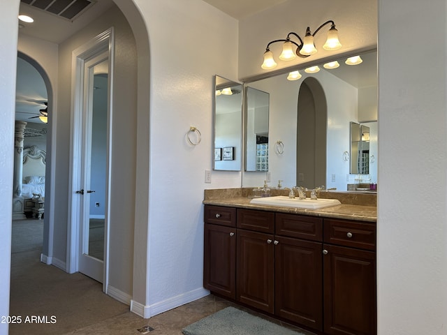 bathroom with vanity, a ceiling fan, visible vents, and baseboards