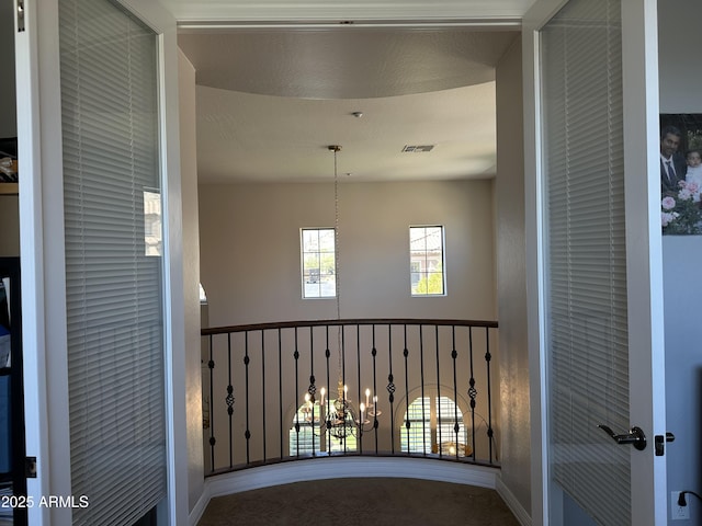 corridor featuring visible vents and an inviting chandelier