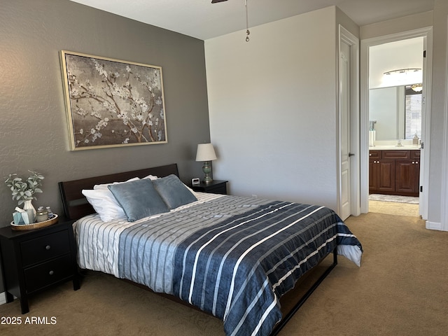 bedroom with ensuite bath and light colored carpet
