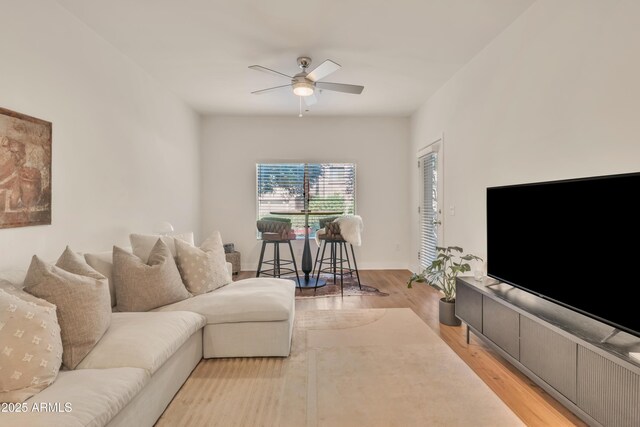 5450 E Deer Valley Dr Unit 1004, Phoenix, AZ 85054 - living room featuring ceiling fan, light wood-style floors, and baseboards