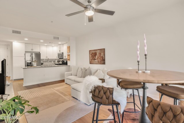 5450 E Deer Valley Dr Unit 1004, Phoenix, AZ 85054 - living room featuring light wood-style flooring, a ceiling fan, and recessed lighting