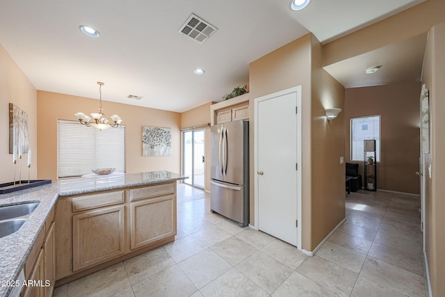 kitchen featuring visible vents, light brown cabinetry, light tile patterned floors, freestanding refrigerator, and a chandelier