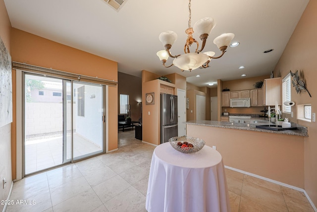 kitchen featuring a notable chandelier, freestanding refrigerator, light tile patterned floors, white microwave, and visible vents