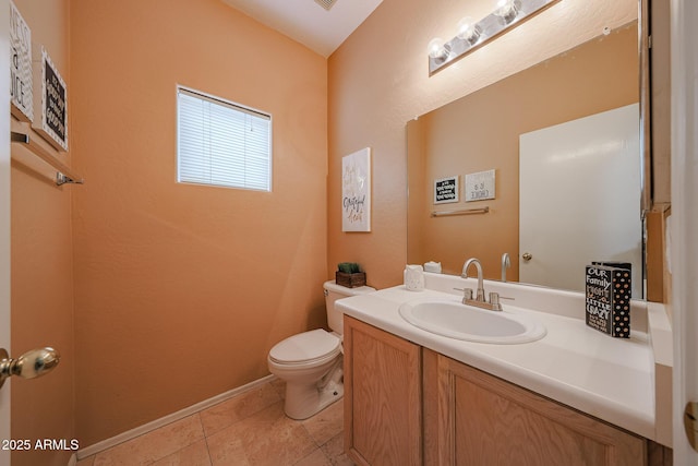 half bathroom featuring vanity, tile patterned flooring, and toilet