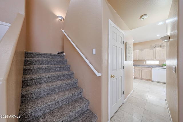 staircase featuring tile patterned floors and recessed lighting