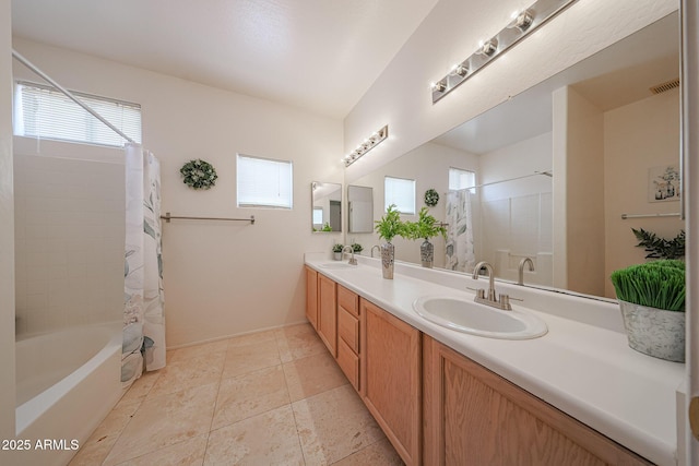 full bathroom featuring plenty of natural light, a sink, and double vanity