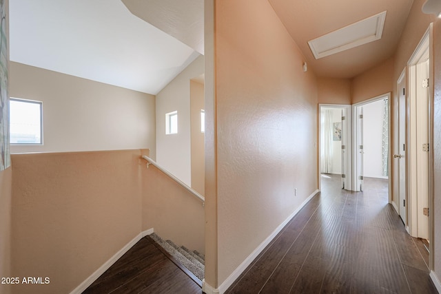 hall with plenty of natural light, baseboards, and dark wood-style floors