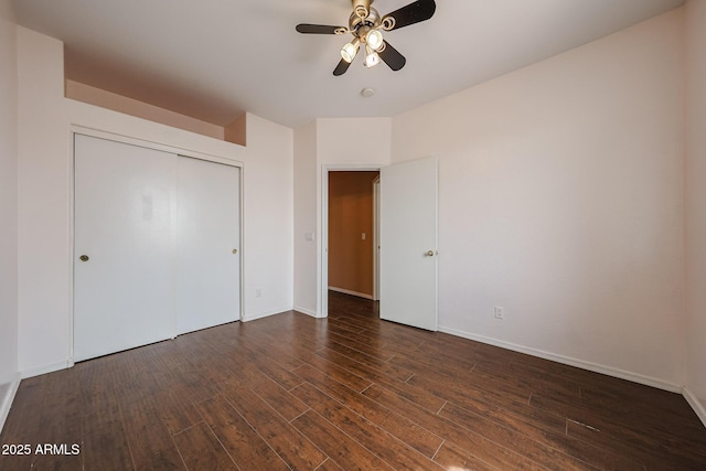 unfurnished bedroom featuring baseboards, wood finished floors, and a closet